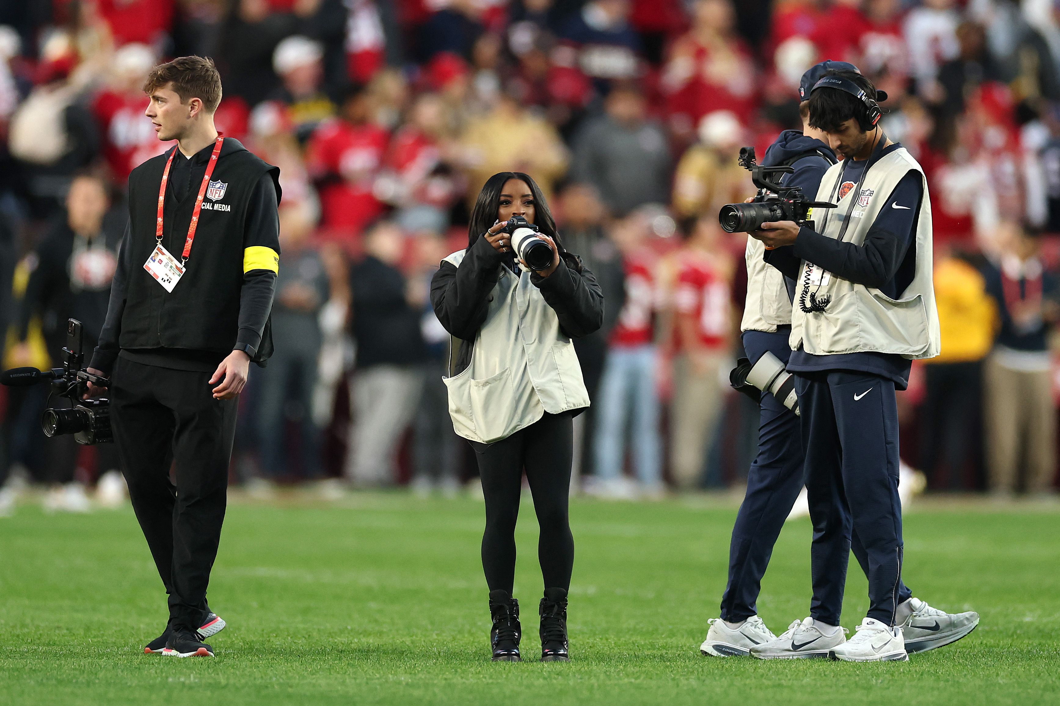 SANTA CLARA, CALIFORNIA - DECEMBER 28: Gymnast Simone Biles takes photos on the field before the game between the san Francisco 49ers and the Chicago Bears at Levi